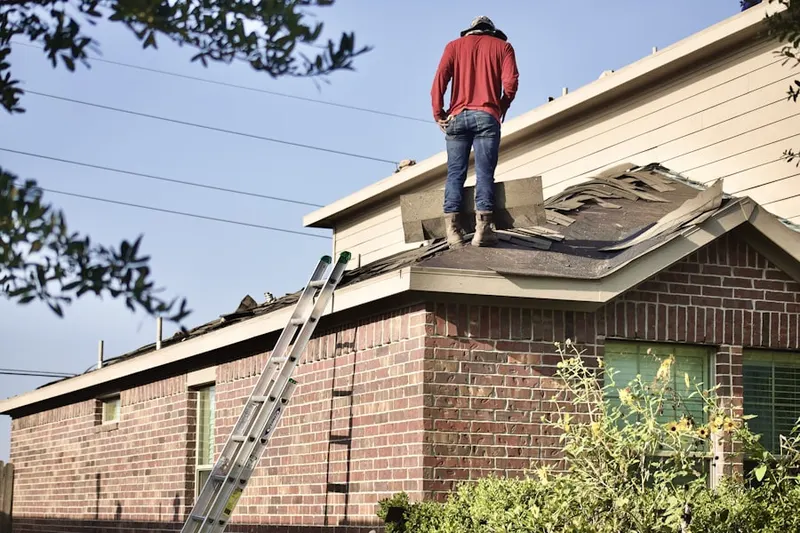 Professional roofer working on a residential roof in Warrensburg